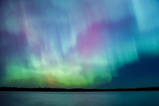 The Aurora Borealis (Northern Lights) in the night sky, reflecting off a lake in the Boundary Waters Canoe Area Wilderness (BWCA) Minnesota