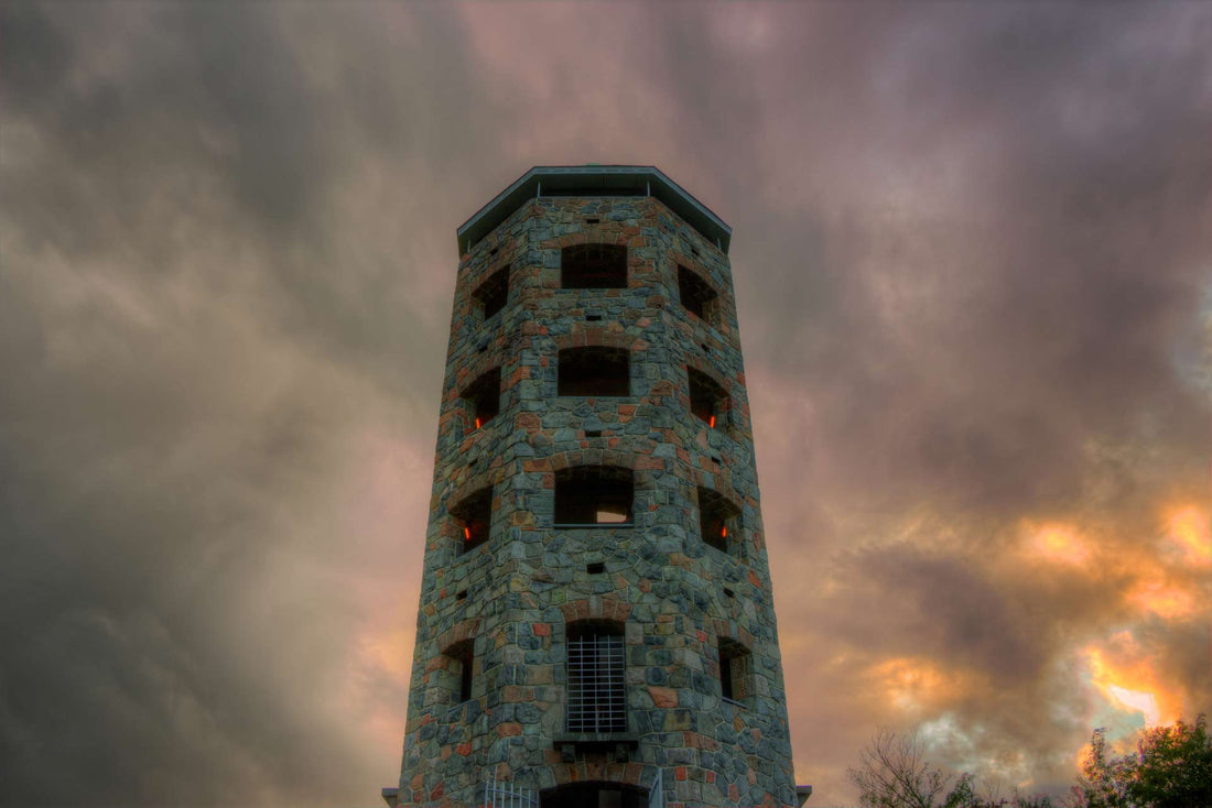 A spooky photo of the haunted Enger Tower in Minnesota against a cloudy-gray background